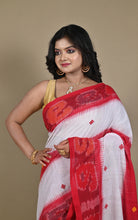 Close-up of red kotki ikat border and woven red buti on white cotton