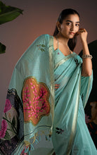 Close-up detail of sea green Jamdani saree highlighting the orange-terracotta botanical medallion and flowing pallu.