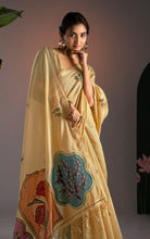 Close-up portrait of model wearing pastel yellow Jamdani saree highlighting the teal botanical medallion and gold hoop earrings.