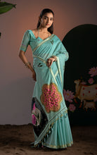 Model posing in sea green Jamdani saree displaying the multi-colored arch motifs and handcrafted tassels.