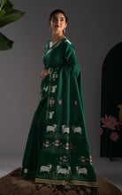 Side profile displaying the rich woven border and flowing pallu.