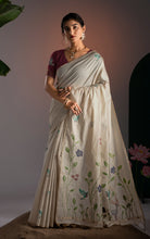 Studio portrait of model wearing off-white Jamdani saree paired with maroon blouse and gold jewelry.