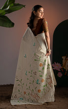 Back view showing full pallu spread of a cream Jamdani saree with intricate bird, deer, and green floral vines.