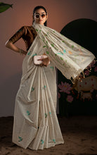 Model styling a cream soft Jamdani saree with trendy sunglasses and a clutch, displaying the lightweight weave.