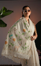 Close up of hand-woven fawn deer motif and amber flowers on cream soft Jamdani saree pallu with tassels.