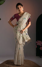 Model wearing cream Jamdani saree with maroon contrast blouse showcasing handloom floral and bird weave details.